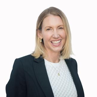 Ann Larson wearing a black blazer and white shirt