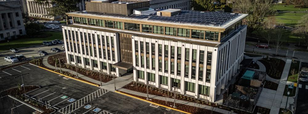 A bird's eye view of the Irving R. Newhouse Building, showing the new structure and parking lot, with the West Campus lawns and Capitol Group buildings visible in the background.