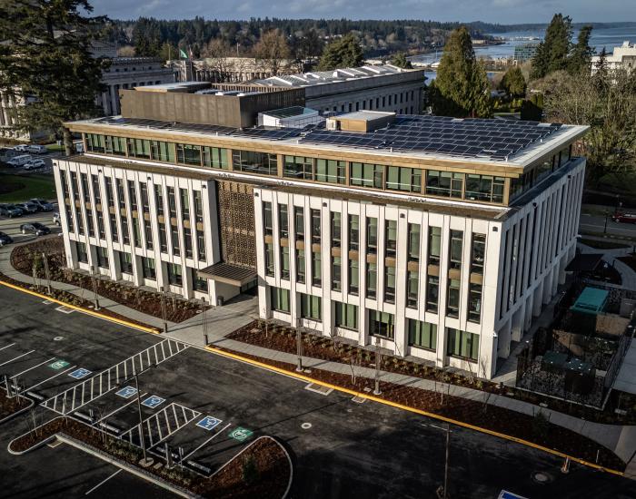 A bird's eye view of the Irving R. Newhouse Building, showing the new structure and parking lot, with the West Campus lawns and Capitol Group buildings visible in the background.